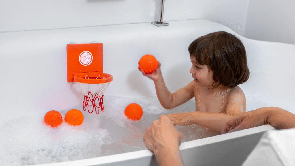 Marppy Bath Basketball Hoop – toddler playing with orange striped balls and hoop in bathtub, fun and safe bath toy for kids